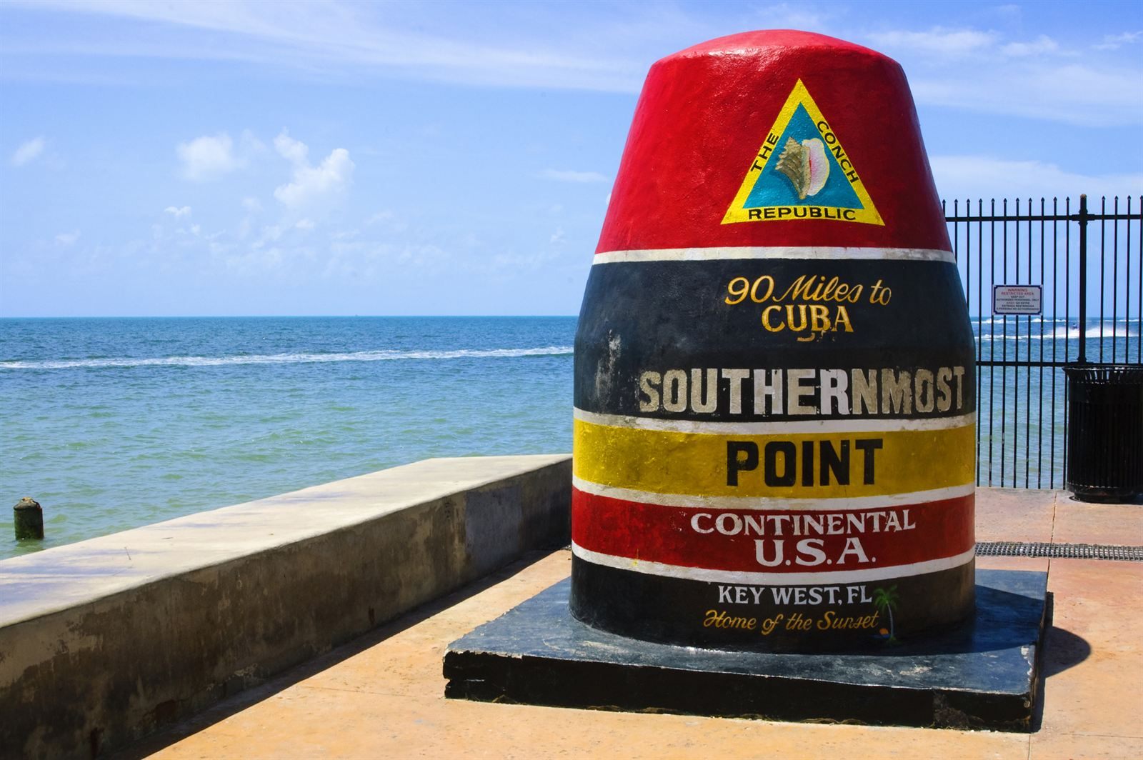 The striped Southernmost Point buoy in Key West, Florida, beside the sea