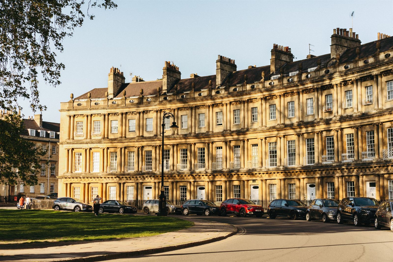 Curved Georgian terrace of honey-colored stone houses in Bath, England
